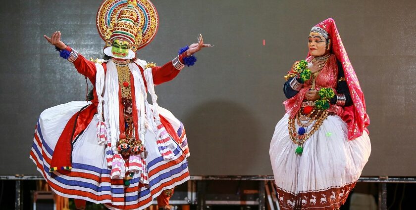 Two people in traditional clothes performing at a vibrant harvest festival of Kerala.