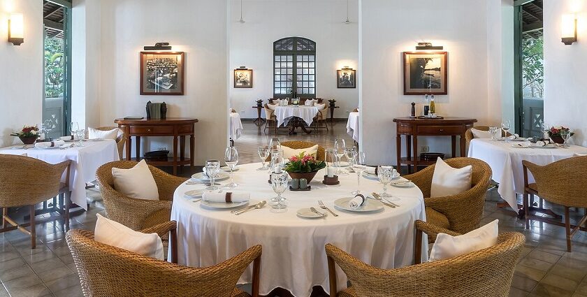 A spacious, elegant dining room with round tables and wicker chairs, and a smaller room in the back, one of the best Indian restaurants in Singapore.