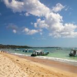 Sandy shore and calm waters with boats docked at Nusa Lembongan, one of the best islands in Bali.