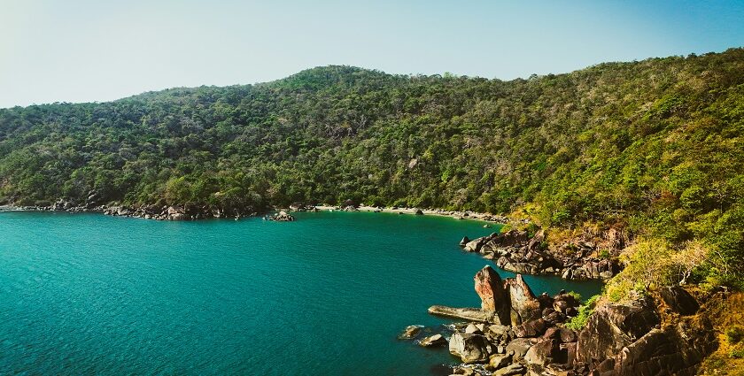 Butterfly Beach, with calm water surrounded by green hills, one of the best offbeat places in Goa.