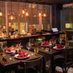 Elegant dining space with glowing lights, festive décor, and tables set with red napkins, one of the best restaurants in Clarke Quay.