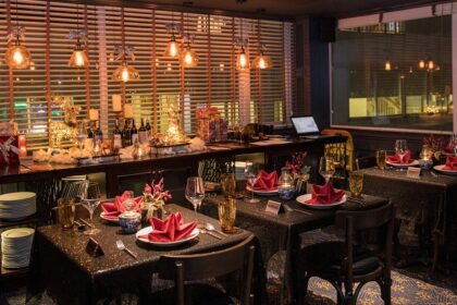 Elegant dining space with glowing lights, festive décor, and tables set with red napkins, one of the best restaurants in Clarke Quay.