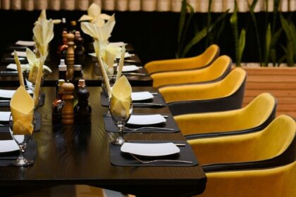 Khushboo restaurant interior with yellow chairs, one of the best restaurants in Fancy Bazar Guwahati.