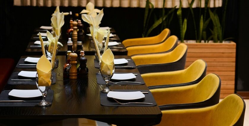 Khushboo restaurant interior with yellow chairs, one of the best restaurants in Fancy Bazar Guwahati.