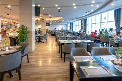 Spacious modern restaurant with wooden flooring, bright lighting, and diners near windows among the multiple restaurants in Havelock Island.