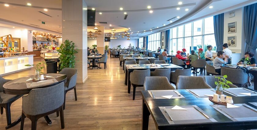 Spacious modern restaurant with wooden flooring, bright lighting, and diners near windows among the multiple restaurants in Havelock Island.