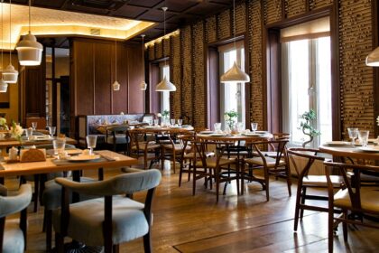 Cosy interior of Café Kurseong Diaries with tables, chairs, and hanging lights, one of the best restaurants in Kurseong.