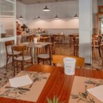 A restaurant with wooden chairs, pendant lights, and a warm interior, one of the best restaurants in Namchi.