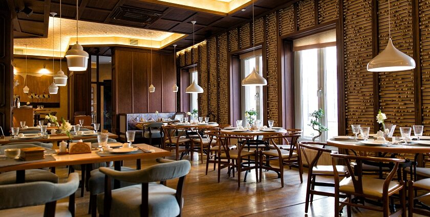 A room with tables and chairs under dim lighting, one of the best restaurants in Neil Island.
