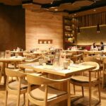 A large room with tables and chairs at The Deck, one of the restaurants in Sevoke Road Siliguri.