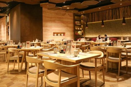 A large room with tables and chairs at The Deck, one of the restaurants in Sevoke Road Siliguri.