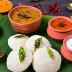 Idli and sambar with chutneys served on a banana leaf at South Indian restaurants in Kuala Lumpur.