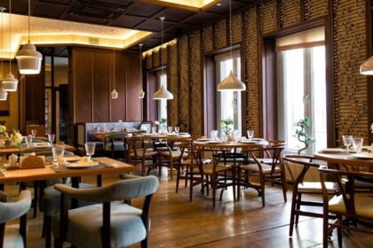 The Ganga cafe interior with wooden furniture, and hanging lights, one of the best veg restaurants in Malaysia.