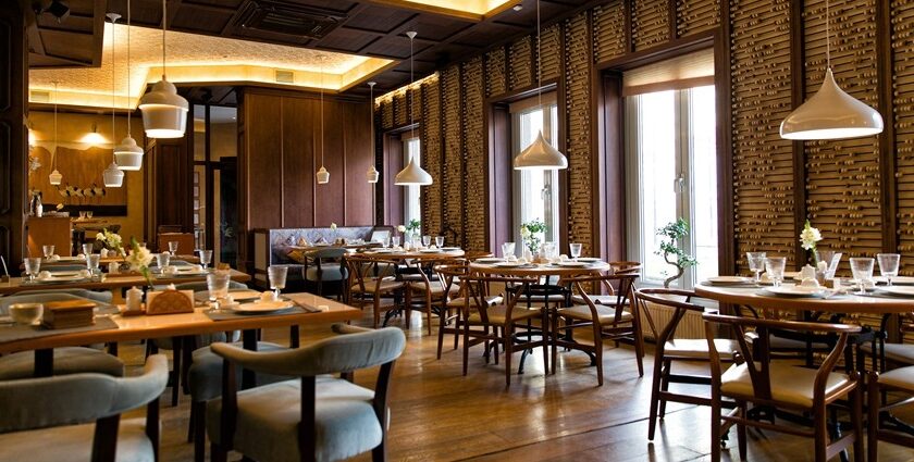 The Ganga cafe interior with wooden furniture, and hanging lights, one of the best veg restaurants in Malaysia.