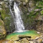 Majestic waterfall surrounded by lush green mountains, showcasing waterfalls in Rajasthan.