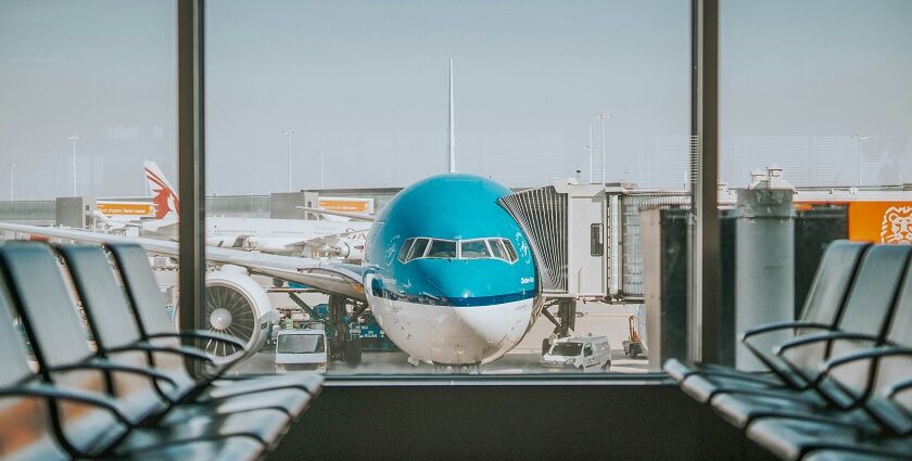 Waiting area with large window and view of airplane on runway at airports in Kashmir.