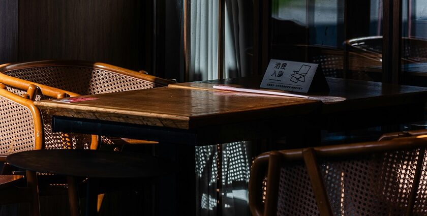 The Socialite interior with cozy indoor cafe table and rattan chairs at one of the best restaurants in Guwahati for couples.
