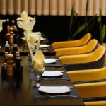11th Avenue Café interior with long table, yellow chairs, and black cloth in one of the vibrant cafes in Jayanagar Guwahati.