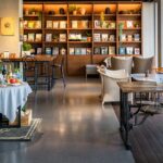 Cosy black coffee cafe interior with wooden furniture and a bookshelf, one of the trendy cafes in Zoo Road Guwahati.