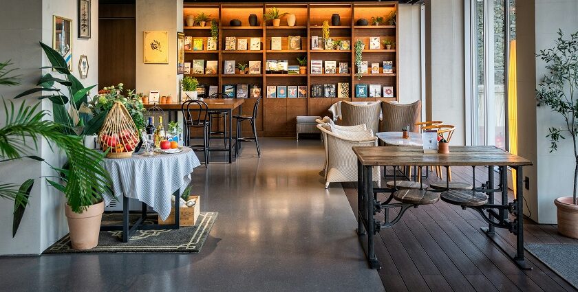 Cosy black coffee cafe interior with wooden furniture and a bookshelf, one of the trendy cafes in Zoo Road Guwahati.
