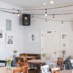 Cosy interior of The Coffee Shop with hanging lights, tables, and aesthetic decor, one of the best cafes in MG Marg Gangtok.