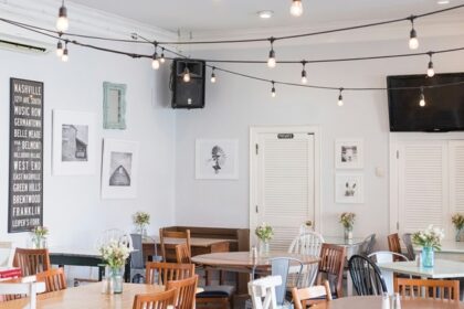 Cosy interior of The Coffee Shop with hanging lights, tables, and aesthetic decor, one of the best cafes in MG Marg Gangtok.