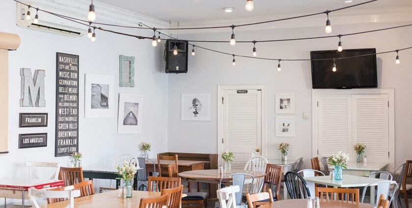 Cosy interior of The Coffee Shop with hanging lights, tables, and aesthetic decor, one of the best cafes in MG Marg Gangtok.