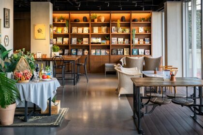 Salt & Pepper Bistro interior with tables, chairs, and wall-mounted bookshelf, one of the best couple restaurants in Dibrugarh.