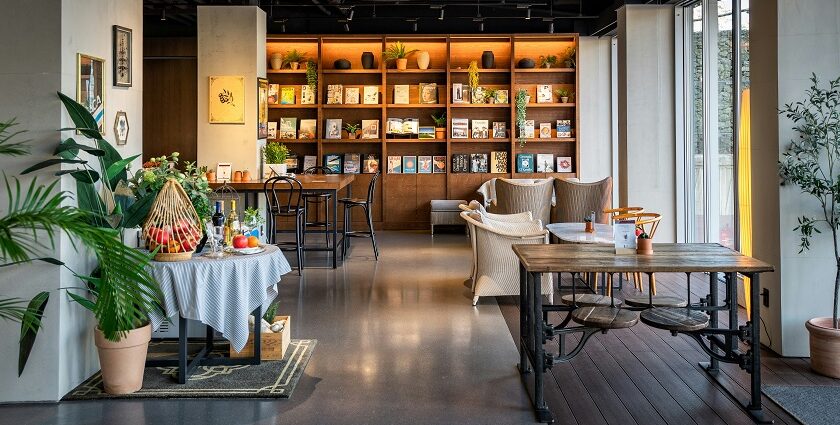 Salt & Pepper Bistro interior with tables, chairs, and wall-mounted bookshelf, one of the best couple restaurants in Dibrugarh.