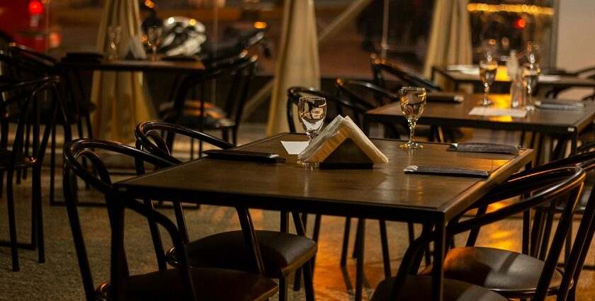 Dimly lit restaurant tables set with glasses and napkins, facing a street view at night, one of the best restaurants in Aizawl.