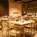 Cosy interior of Nagameez with table, chairs, and dim lights, one of the best restaurants in Beltola Guwahati.