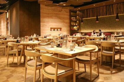 Cosy interior of Nagameez with table, chairs, and dim lights, one of the best restaurants in Beltola Guwahati.