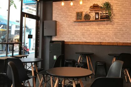 Interior of a restaurant with black tables, chairs, and light fixtures, one of the restaurants in Jowai.