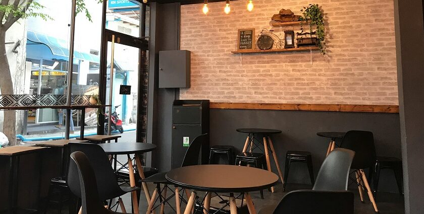 Interior of a restaurant with black tables, chairs, and light fixtures, one of the restaurants in Jowai.