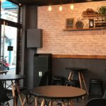 Bombay Brasserie interior with black tables, chairs, and lights, one of the best restaurants Paltan Bazar Guwahati.