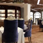 Interior of China Valley Restaurant with white tablecloths and purple chairs restaurants in Pasighat.