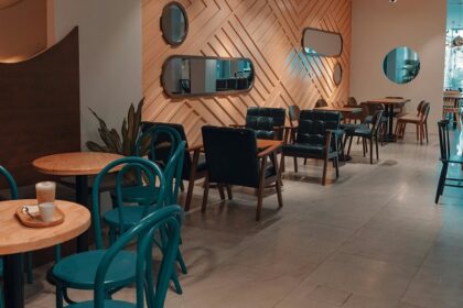 Blue Orchid restaurant interior with wooden accents, teal chairs, and warm ambient lighting, one of the top restaurants in Silchar.