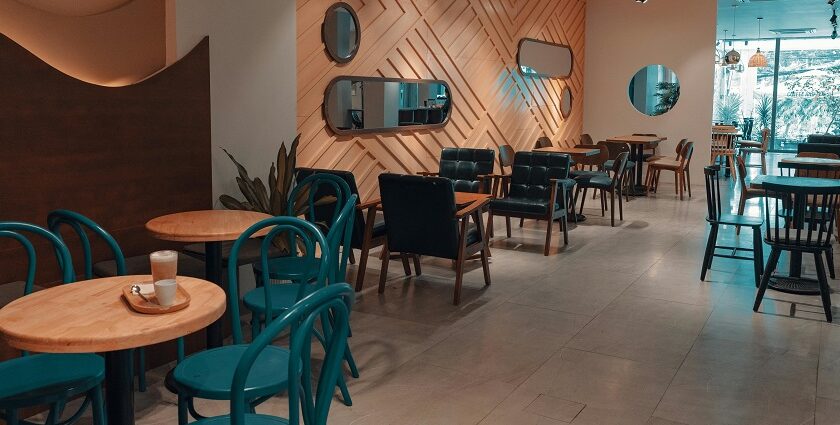 Blue Orchid restaurant interior with wooden accents, teal chairs, and warm ambient lighting, one of the top restaurants in Silchar.