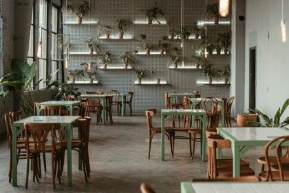 Piazza interior with white tables, chairs, and wall plants, one of the best restaurants in Ulubari Guwahati.