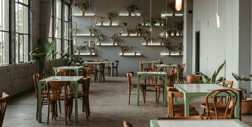 Piazza interior with white tables, chairs, and wall plants, one of the best restaurants in Ulubari Guwahati.