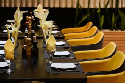 Skyscape Guwahati interior with long table and chairs, one of the best rooftop restaurants in Guwahati.