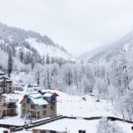 Solang Valley in Manali covered in fresh snow with mountains and pine trees around.
