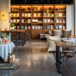 Cosy interior of Jiva South with brown wooden tables, chairs, and a bookshelf, one of the top veg restaurants in Shillong.