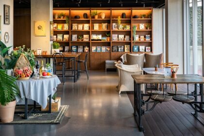 Cosy interior of Jiva South with brown wooden tables, chairs, and a bookshelf, one of the top veg restaurants in Shillong.