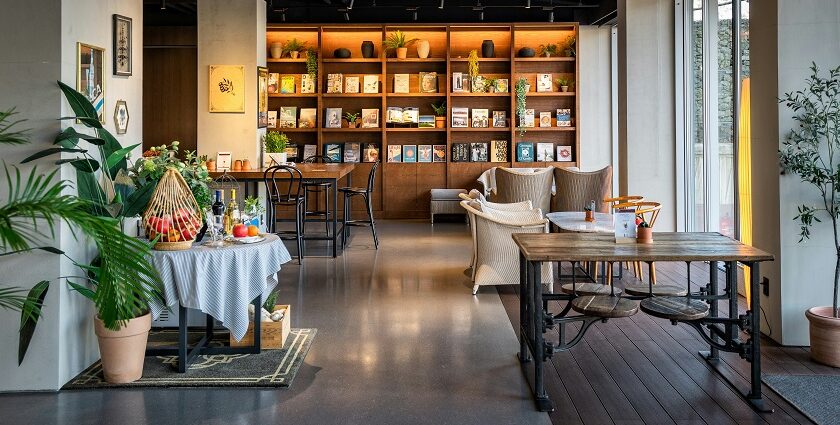 Cosy interior of Jiva South with brown wooden tables, chairs, and a bookshelf, one of the top veg restaurants in Shillong.